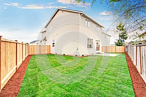 House fenced back yard exterior with well kept lawn