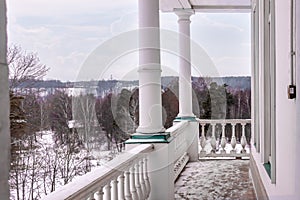 House front porch and columns of white old style home overcast winter sky