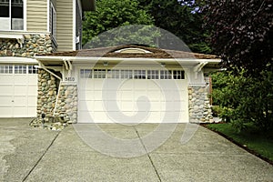 House garage with stone trim and tile roof
