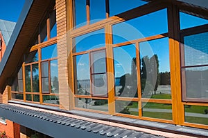 House with a gray metal roof and large windows on the facade. Co