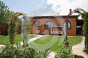a house in a green garden. wooden house in the backyard. summer, lawn, swing
