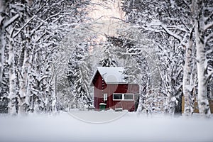 The house has covered with heavy snow and sunset time in winter season at Holiday Village Kuukiuru, Finland