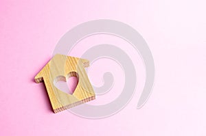 House with a heart on a pink background. The concept of finding a rental house or apartment for a romantic pastime.