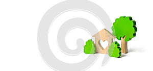 A house with a heart and wooden figures of trees with bushes on an isolated background. love nest. Acquisition of affordable photo