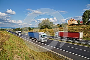House of highway in a rural landscape, three trucks on the road