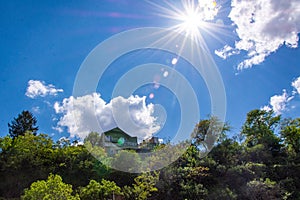 House on the hill. Sunny dav, blue sky, white clouds