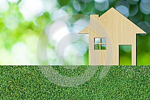 House icon from wooden on grass texture nature background as symbol of mortgage