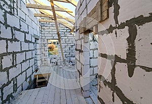 House interior under construction and renovation. Energy saving walls of hollow foam insulation blocks and bricks, ceiling beams