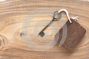 House key in heart shape with home keyring on old wood background