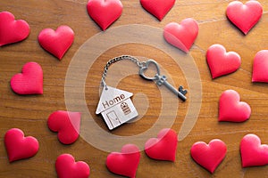 House key with home keyring decorated with mini heart on rusty wood background