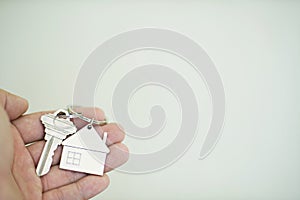 House key with home keyring on hand, property concept
