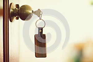 House key with home keyring in keyhole, property concept