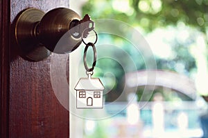 House key with home keyring in keyhole, property concept