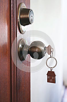 House key with home keyring in keyhole, property concept