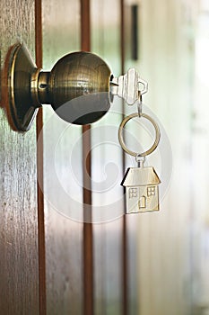 House key with home keyring in keyhole, property concept