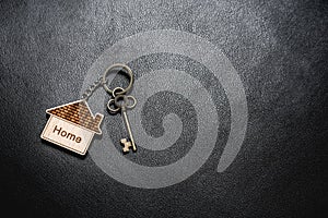 House key with home keyring on rusty wood background