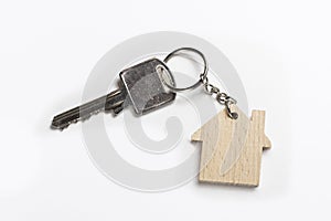 House key on house shaped keyring on white background
