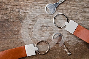 House key with leather key chain on wooden background
