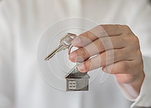 House key in real estate sale person, landlord or home Insurance broker agent`s hand giving to buyer customer for new family owner