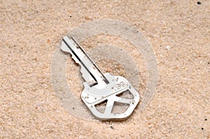 A house key in the sand