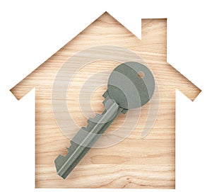 House and key shaped paper cutout on natural wood lumber.