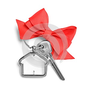 House key with trinket and bow on white background