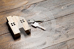 house and key on a wooden surface top view apartment rental
