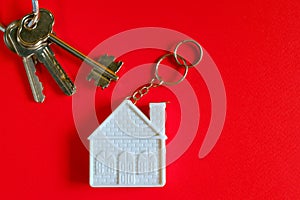 House with keys on color background. Minimalism concept of real estate.
