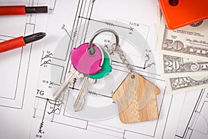 House keys, currencies dollar, electrical construction diagrams and work tools for engineering jobs. Building or buying home