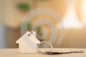 House keys on keyring in the shape of a wooden house with copy-space for text