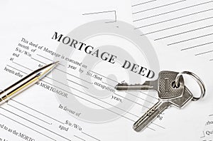 House Keys with pen on mortgage deed form. Top view