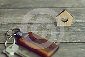 House keys with wooden home keying on wood table, copy space, property concept