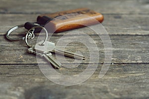 House keys with wooden home keying on wood table, copy space, property concept