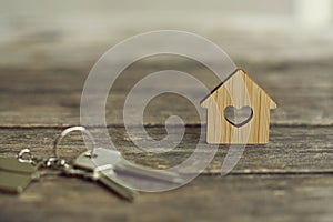 House keys with wooden home keying on wood table, copy space, property concept