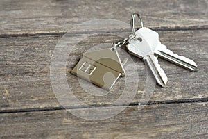 House keys with wooden home keying on wood table, copy space, property concept