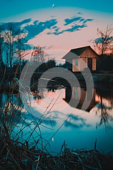 House at the lake reflected on water in twilight
