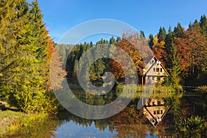 House by the lake, surrounded forest