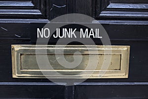 House letterbox with `No junk mail` sign and junk mail