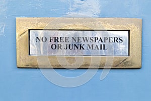 House letterbox with `No junk mail` sign and junk mail