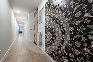 House with a long corridor with a wooden floor and a wall covered