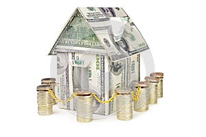 House made of money surrounded by a fence from coins