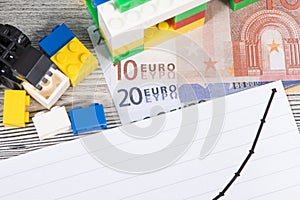 House made of toy blocks, euro banknotes and rising graph representing increase in prices of building or purchasing home