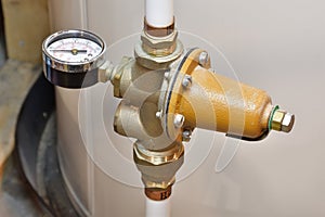 House main water feed pipe. Water line pressure regulator and pressure gauge mounted on PEX white tubes.