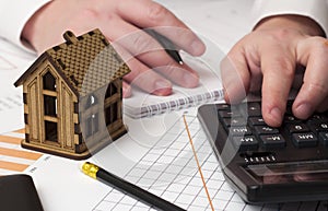 House and the man's hand considers on the calculator