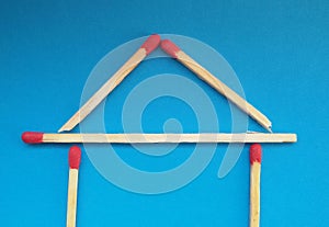 A house of matchsticks over blue background.