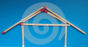 A house of matchsticks over blue background.