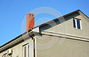 House with metal roof, brick chimney, rain gutter and insulate plaster wall outdoors photo