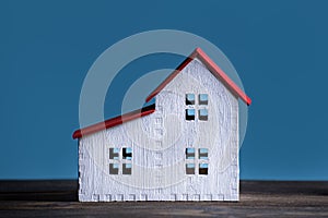 House model on blue background. Home construction concept. Front view closeup