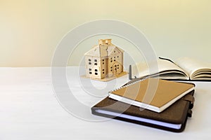 House model and book on the desk. real estate, home loan and investments concept