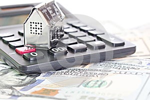 House model, calculator and American Dollar cash money on office desk table